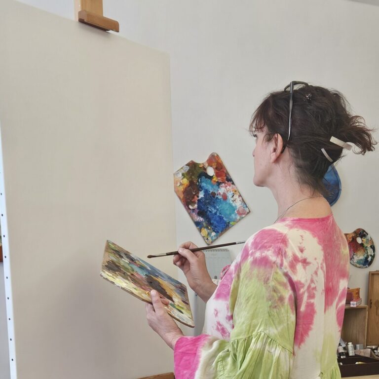 AjnaStella, artiste peintre intuitive, en train de créer une toile dans son atelier